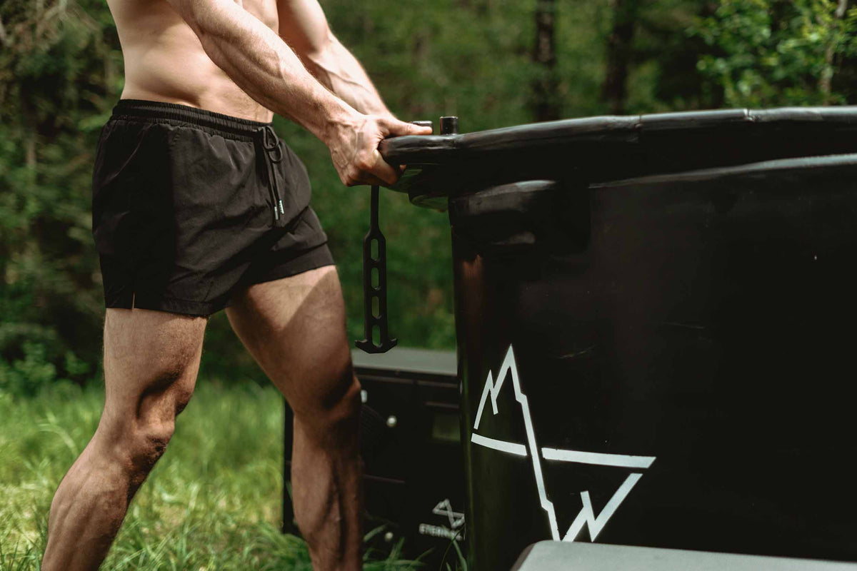 A man removes the lid from his cold plunge