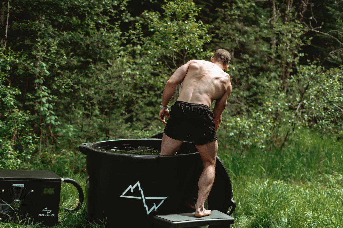 A man entering the HD Pro cold plunge tub outdoors